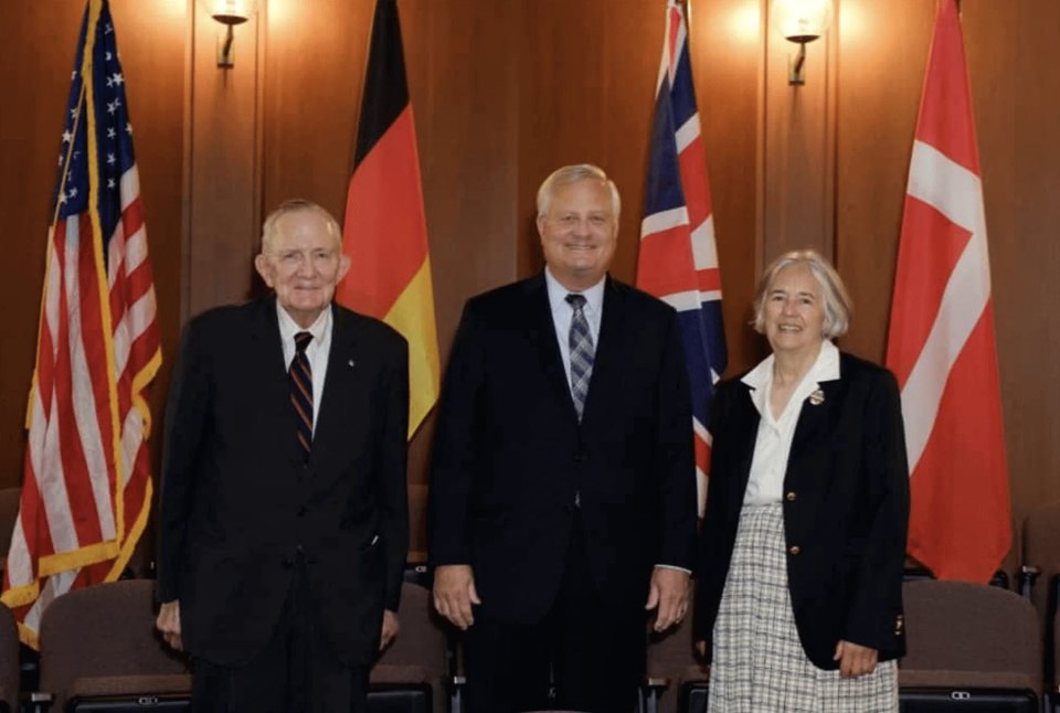 Members from each historic Moravian community posing in front of the countries' flags